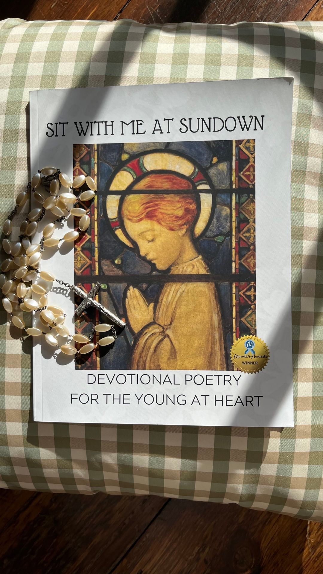 This is a photo of a dementia friendly books of hymns and a pearlized rosary beads lying on a cushion in a sunlit room.  NANA’S BOOKS series of nostalgic prayers, psalms and poetry make wonderful gifts for people to share. Large print books with adaptive formats ease reading and create opportunities for frustration free visiting. Caregivers and people living with memory challenges alike appreciate these thoughtful dementia resources. 