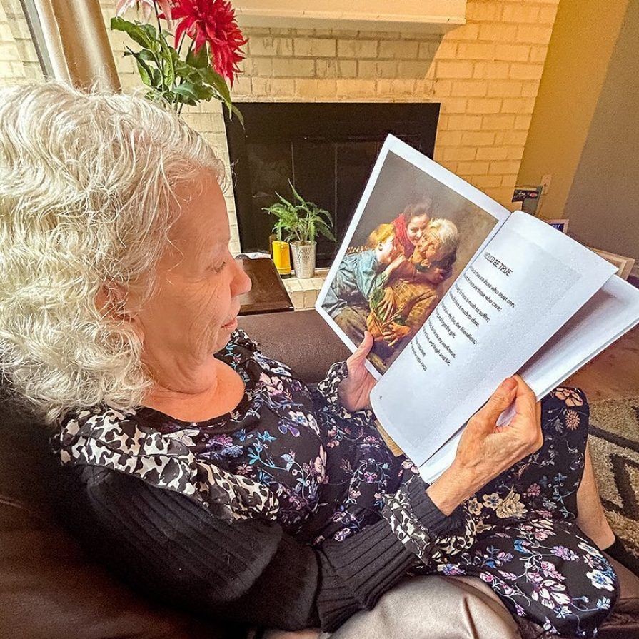 A gray-haired woman in Galveston, Texas enjoys a nostalgic picture book in her assisted living facility. NANA’S BOOKS are enjoyed in communities and independently in home health care.